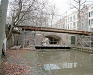 838524 Gezicht op de Quintijnsbrug over de Nieuwegracht te Utrecht, die gerestaureerd wordt.